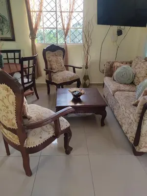 a living room with a couch and a table and chairs at Paris London hause in Los Grini