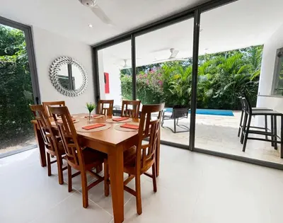 a dining room with a wooden table and chairs at Tropical VILLAGE in Las Terrenas