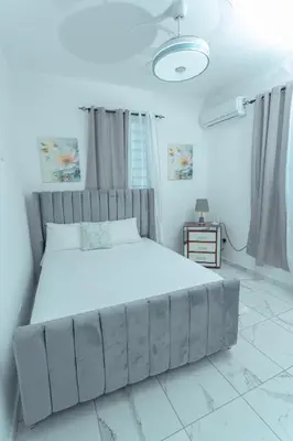 a bedroom with a large bed in a white room at Ventura Living in Nagua