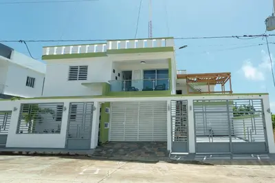 a white house with a gate in front of it at Ventura Living in Nagua
