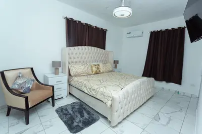 a bedroom with a large bed and a chair at Ventura Living in Nagua
