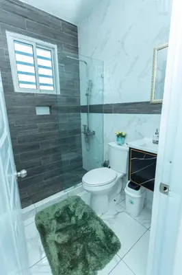 a bathroom with a toilet and a glass shower at Ventura Living in Nagua