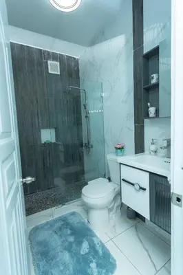 a bathroom with a toilet and a shower and a sink at Ventura Living in Nagua