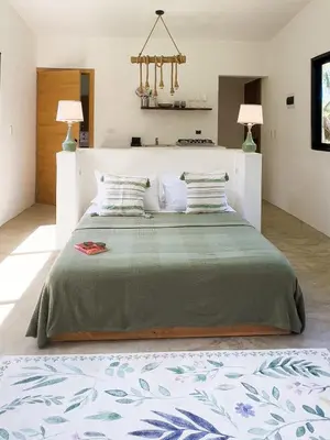 a bedroom with a large bed with two lamps at Jungle Tiny House in El Valle