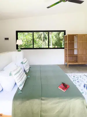 a bedroom with a large bed with a large window at Jungle Tiny House in El Valle