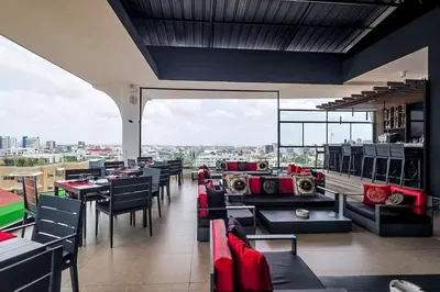 a restaurant with tables and chairs and a view of a city at Cozy 2BR Condo, Spectacular Rooftop in Santo Domingo