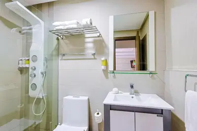 a bathroom with a toilet and a sink and a mirror at Cozy 2BR Condo, Spectacular Rooftop in Santo Domingo