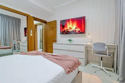 a bedroom with a bed and a desk and a chair at Comfy 2BR Condo, Roof Top Pool. in Santo Domingo