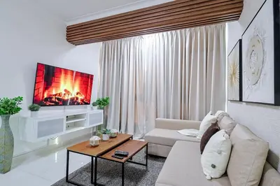 a living room with a couch and a tv at Comfy 2BR Condo, Roof Top Pool. in Santo Domingo