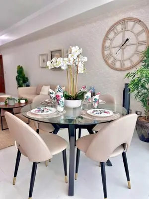 a dining room with a table with chairs and a clock at Elegant City-Center Luxury Apt in Santo Domingo