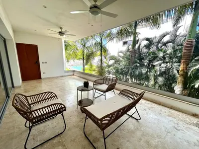 a room with two chairs and a table and a large window at Modern 2BD With Pool And Huge Private Terrace in Las Terrenas
