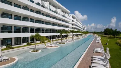a large building with a swimming pool and lounge chairs at Caribbean Heaven in Punta Cana