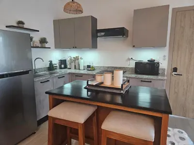 a kitchen with a island with two bar stools at Mireyas Sweet Escape with private Jacuzzi in Las Terrenas