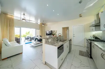 a large kitchen with white appliances and a living room at AC in Living Room, Infinity, Pool Luxury in Sosúa