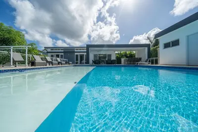 a large swimming pool in front of a house at AC in Living Room, Infinity, Pool Luxury in Sosúa