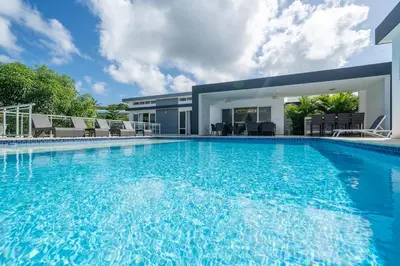 a large swimming pool in front of a house at AC in Living Room, Infinity, Pool Luxury in Sosúa
