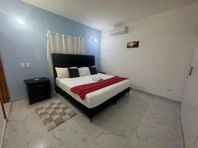a bedroom with a bed with a red blanket at Villa Palacio Verde in Las Terrenas