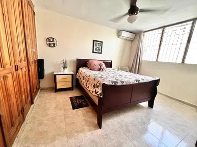 a bedroom with a bed and a television and a window at Alojamiento cerca de Agora y Blue Mall y Cine etc in Santo Domingo