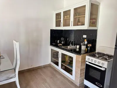 a kitchen with white cabinets and a sink and a stove at La placita in Santa Bárbara de Samaná