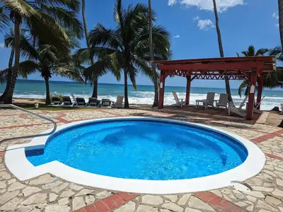 a swimming pool with a gazebo and the beach at Apartamento frente al mar en Albatros in Villas del Mar