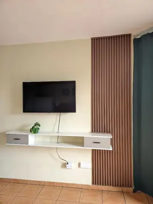 a living room with a television on a wall at Apartamento frente al mar en Albatros in Villas del Mar