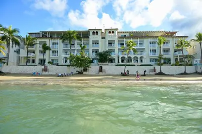 a building on the beach in front of the water at Cabarete Beach Palace 3-BDR Condo in Cabarete
