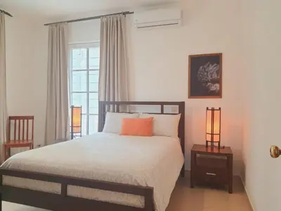 a bedroom with a bed with two lamps and a window at Cabarete Beach Palace 3-BDR Condo in Cabarete