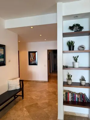 a living room with a bench and bookshelves at Cabarete Beach Palace 3-BDR Condo in Cabarete