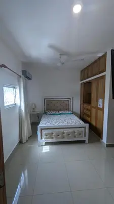 a bedroom with a bed in the middle of a room at Mitaly apartamentos RD H in Santo Domingo