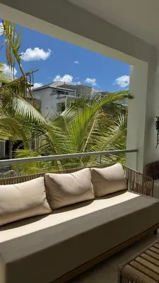 a couch sitting in a room with a large window at Dominica 202 Beachfront Luxury Aqua Esmeralda in Bayahibe