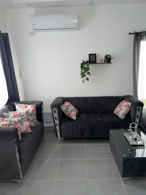 a living room with a black couch and a table at Villa macao in Punta Cana