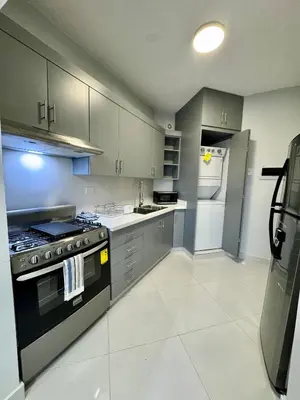 a kitchen with gray cabinets and a stove top oven at Your ideal escape in Puerto Plata Beach and fun in San Felipe de Puerto Plata
