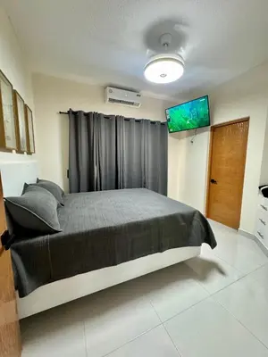 a bedroom with a large bed with a window at Your ideal escape in Puerto Plata Beach and fun in San Felipe de Puerto Plata