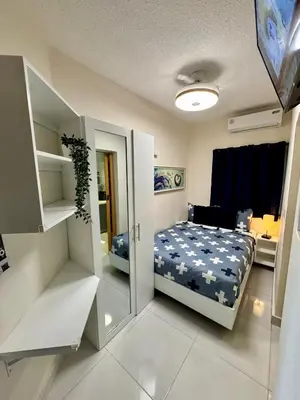 a small bedroom with a bed and a mirror at Affordable room near the beach in San Felipe de Puerto Plata