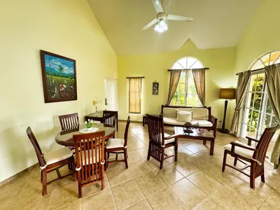 a living room with a table and chairs and a couch at Residencial Hispaniola2 MastersMaidPoolBBQ in Sosúa