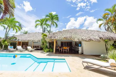 a villa with a swimming pool and a thatch roof at Villa Aurore Las Terrenas, Las Ballenas beach in Las Terrenas