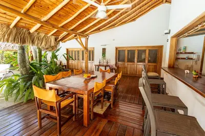 a dining room with a wooden table and chairs at Villa Aurore Las Terrenas, Las Ballenas beach in Las Terrenas