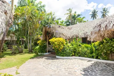 a house with a thatched roof and a courtyard at Villa Aurore Las Terrenas, Las Ballenas beach in Las Terrenas