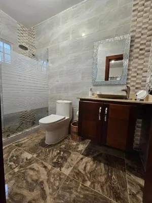 a bathroom with a toilet and a sink and a mirror at Magnificent accommodation in Puerto Plata