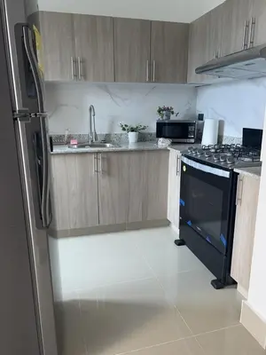 a kitchen with wooden cabinets and a black stove top oven at Beautiful luxury apartment in San Juan de la M in SJM