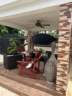 a patio with a table and chairs and a vase at House with Pool and Calm in La Romana