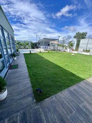 a yard with green grass next to a building at Villa Seven in Guerra