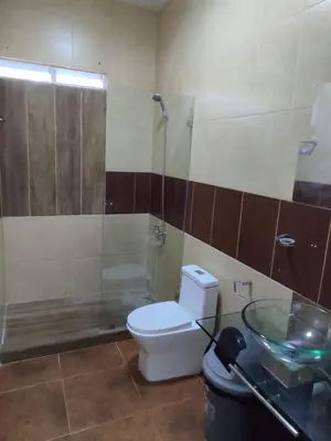 a bathroom with a toilet and a glass shower at Natural Pool Villa perfect for families in Río San Juan