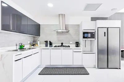 a kitchen with white cabinets and a stainless steel refrigerator at Upscale Condo, Spectacular Views in Santo Domingo