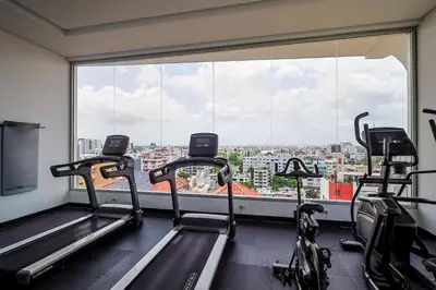 a gym with two tread machines and a large window at Comfy 1BR Apt, King Bed, Pool in Santo Domingo