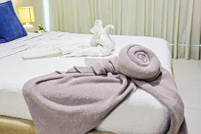a bed with a blanket and a towel on it at Cozy City-Center 1BD Condo, Pool in Santo Domingo