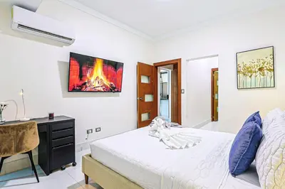 a bedroom with a bed and a desk and a fireplace at Cozy City-Center 1BD Condo, Pool in Santo Domingo
