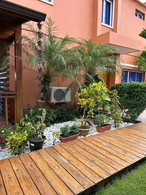 a garden with potted plants and a wooden walkway at Luxury Villa with Pool, jacuzzi,Basketball and more