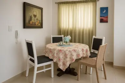 a dining room table with two chairs and a table with a table cloth at Relax cibao airport stay in Santiago de los Caballeros