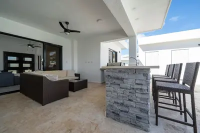a kitchen and living room with a stone fireplace at Luxury Villa, Pool & Prime Location in Sosúa